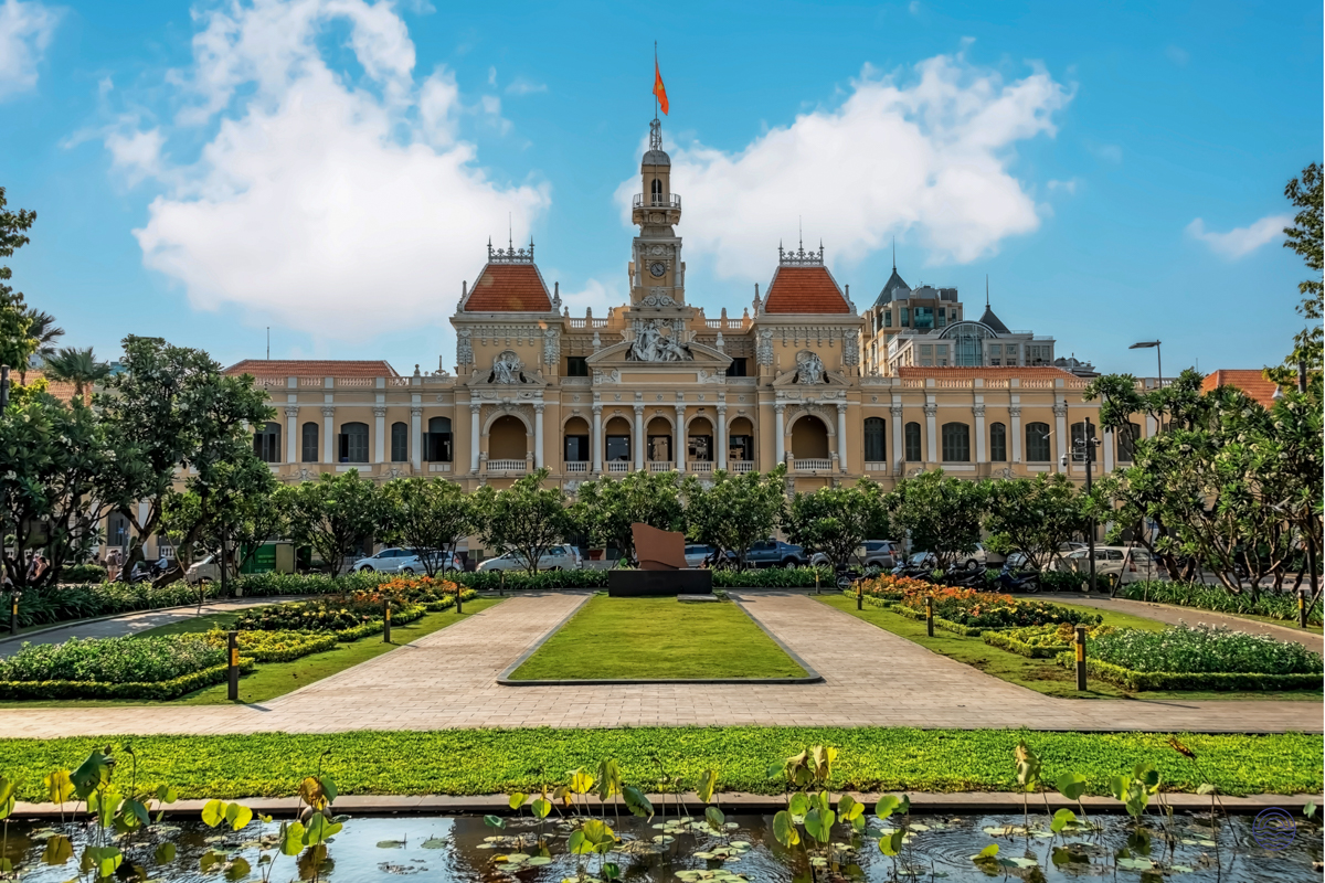 Ho Chi Minh City Hall's grand architecture overlooks a beautiful formal garden with a lily pond.