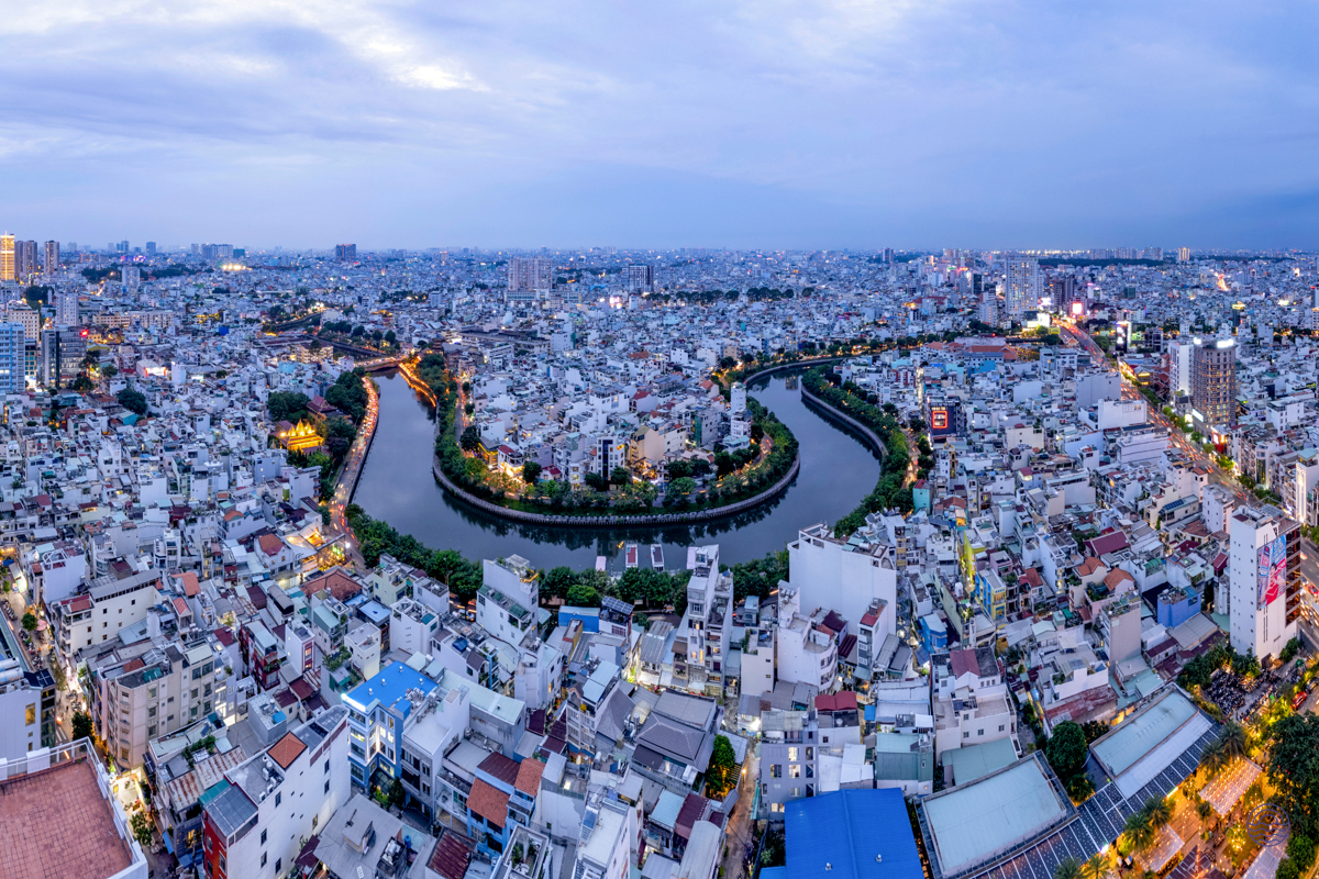 Ho Chi Minh City at dusk, a panoramic view of the winding river and dense urban landscape.