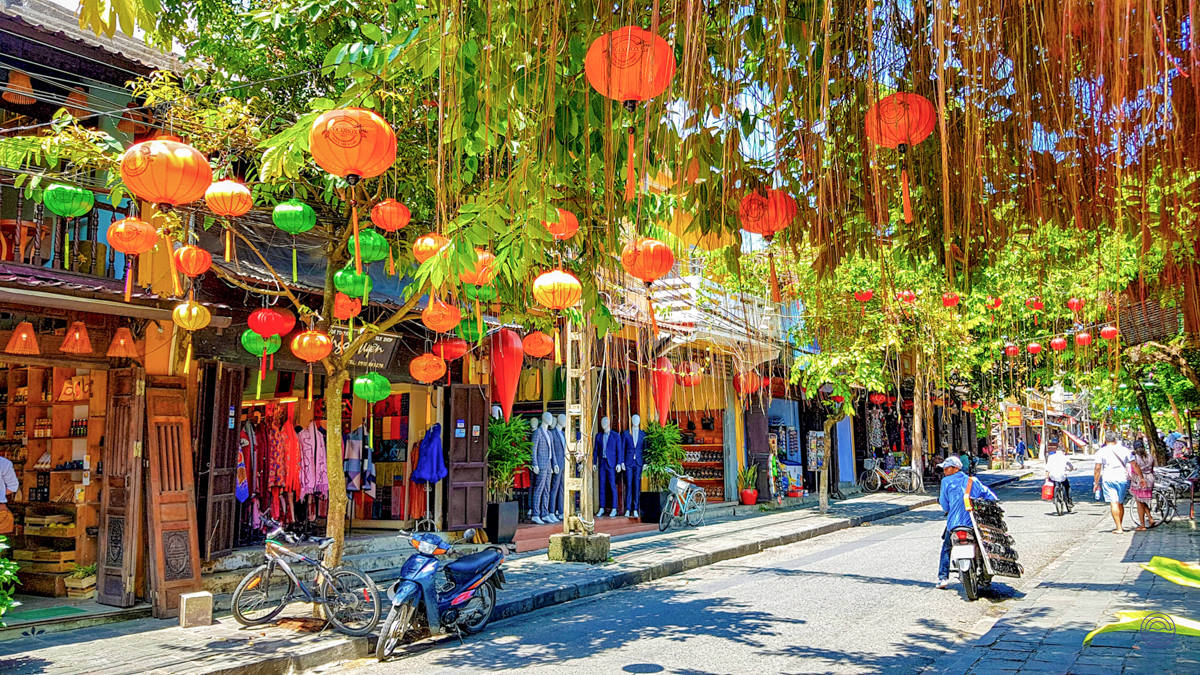 Hoi An's charming streets come alive with colorful lanterns, bustling shops, and people enjoying the day.