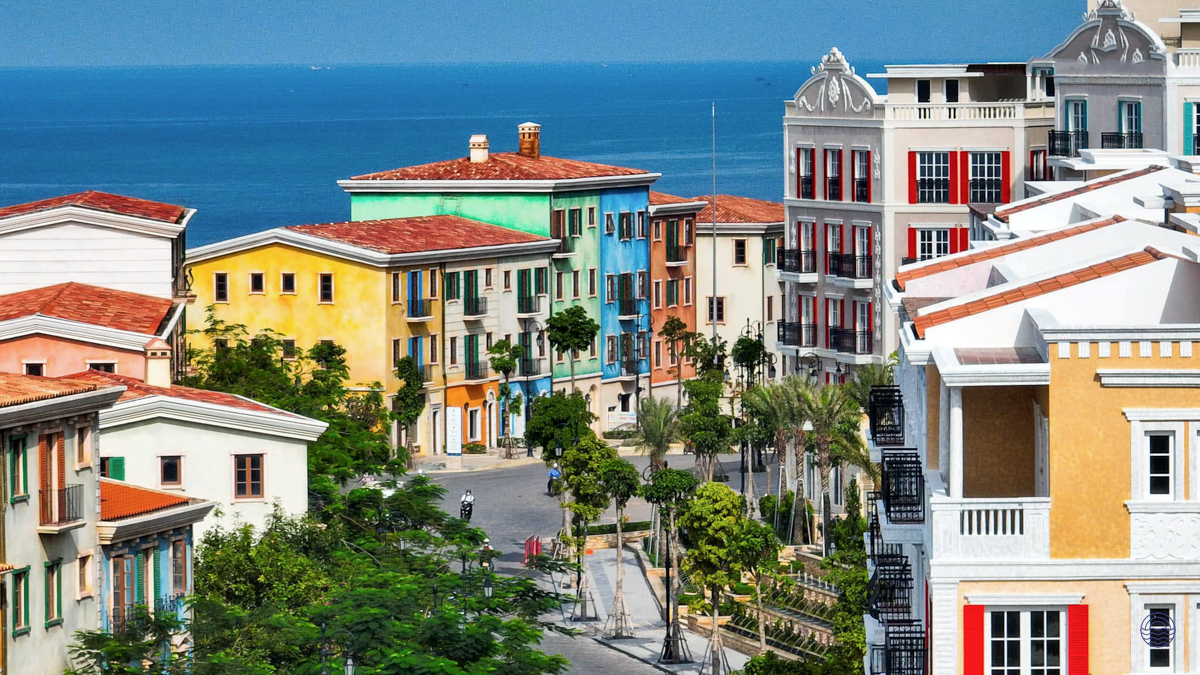 Vibrant Mediterranean-inspired architecture in Sunset Town, Phu Quoc, with the sparkling blue ocean beyond.