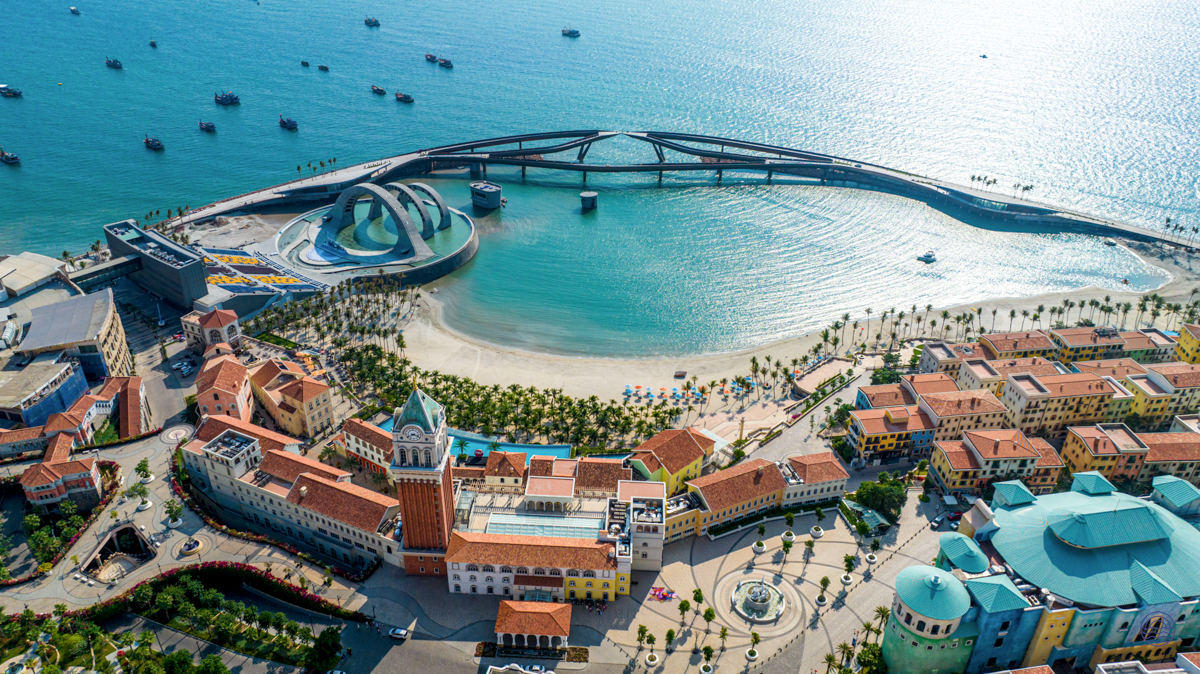 Colorful coastal town in Phu Quoc, featuring a unique bridge, sandy beach, and clear blue bay.
