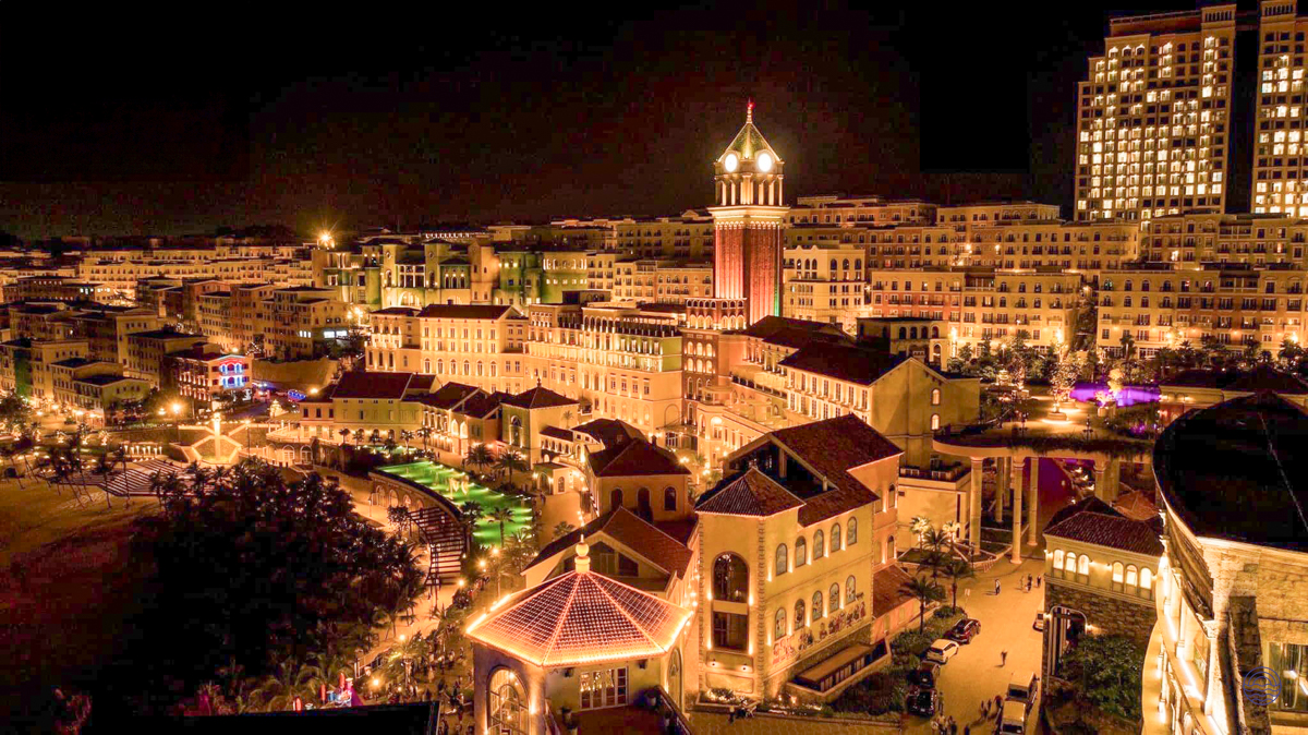 A vibrant night view of Sunset Town in Phu Quoc, with illuminated buildings and a central tower.