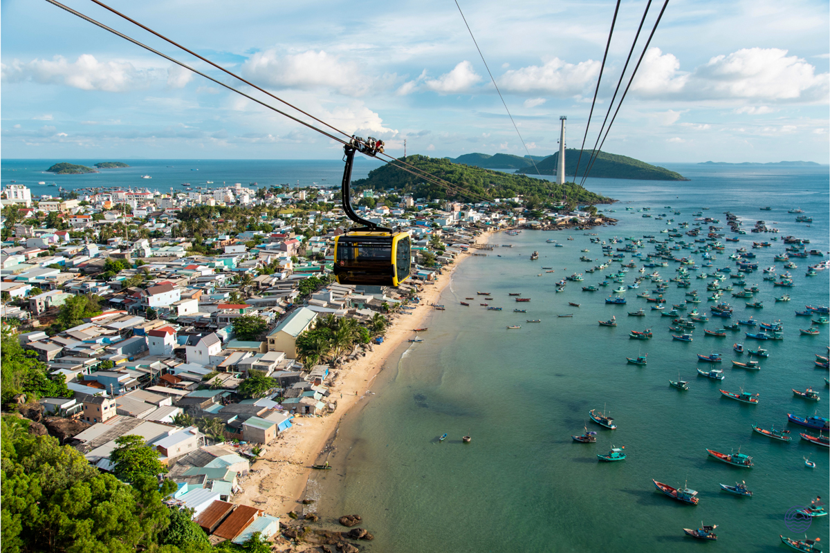 A cable car glides over the vibrant coastal town and fishing boats of Phu Quoc, Vietnam.