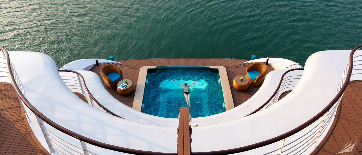 A person swims in a luxurious deck pool on a cruise ship in Halong Bay.