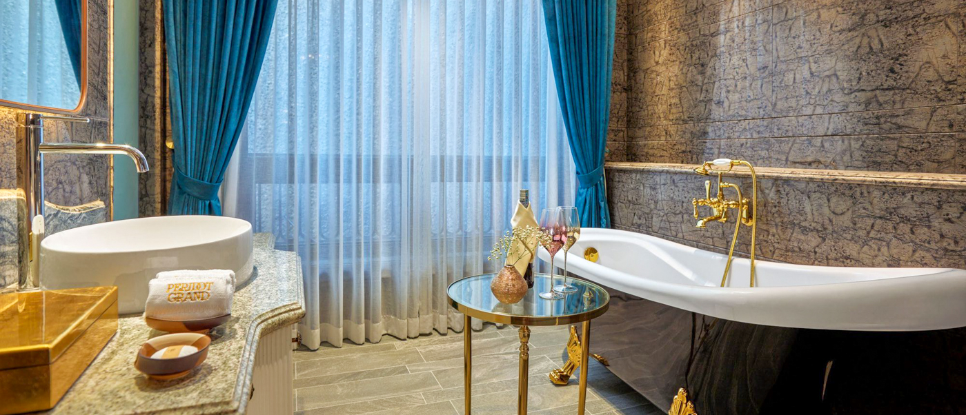 Luxurious hotel bathroom in Hanoi with a freestanding tub, elegant vanity, and champagne for a romantic evening.