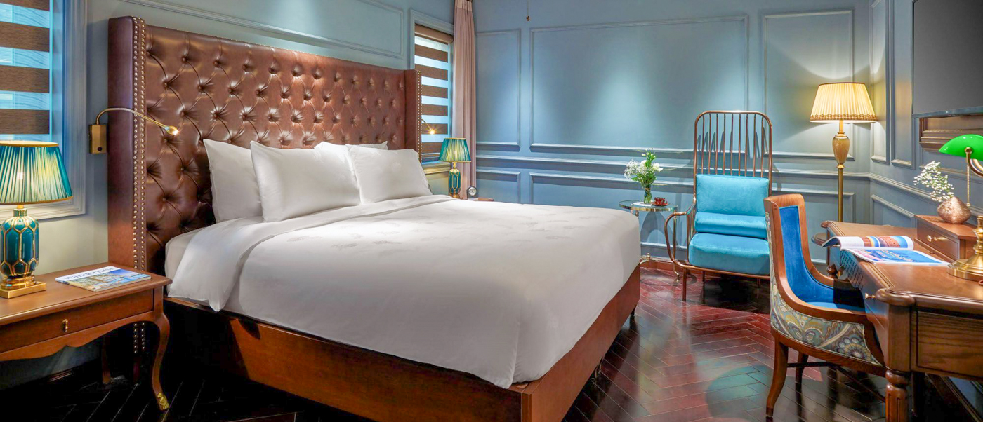 A luxurious bedroom at the Peridot Grand Hotel in Hanoi, featuring a grand bed and elegant furnishings.