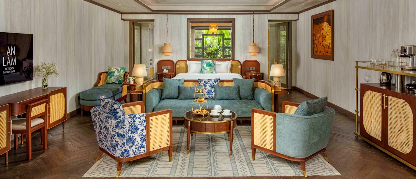 Luxurious villa interior at An Lam Retreats Saigon River, Ho Chi Minh City, with bed and elegant sitting area.