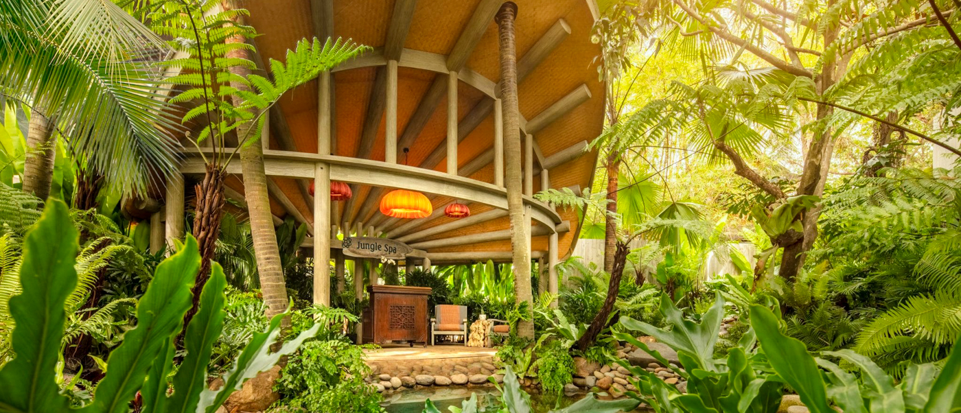 A luxurious circular resort building surrounded by lush tropical greenery and a tranquil pond in Vietnam.