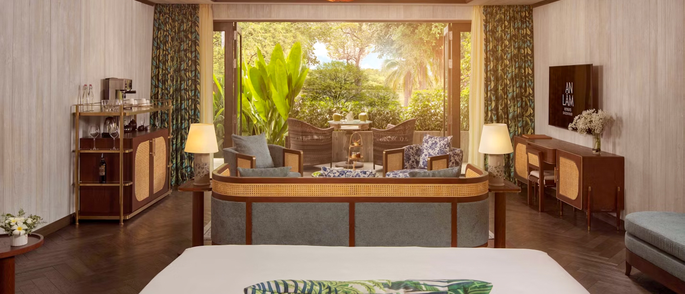 Luxurious villa interior at An Lam Retreats Saigon River, opening to a serene tropical garden.