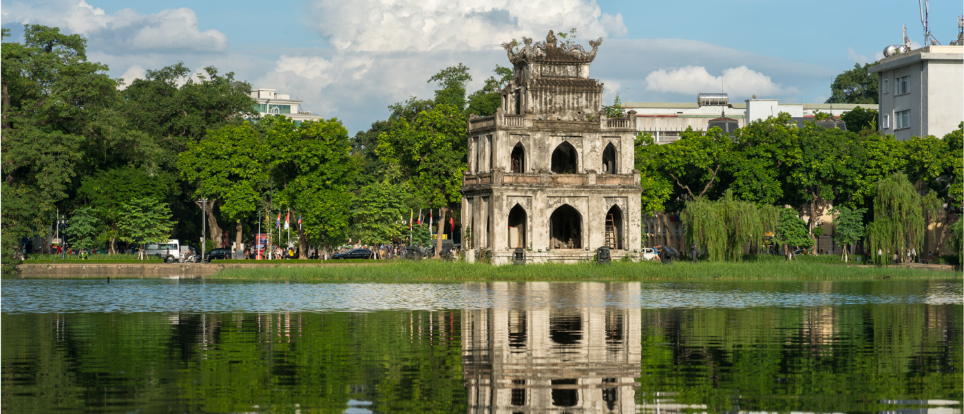 Historic Turtle Tower on Hoan Kiem Lake in Hanoi, reflected beautifully in the calm water.