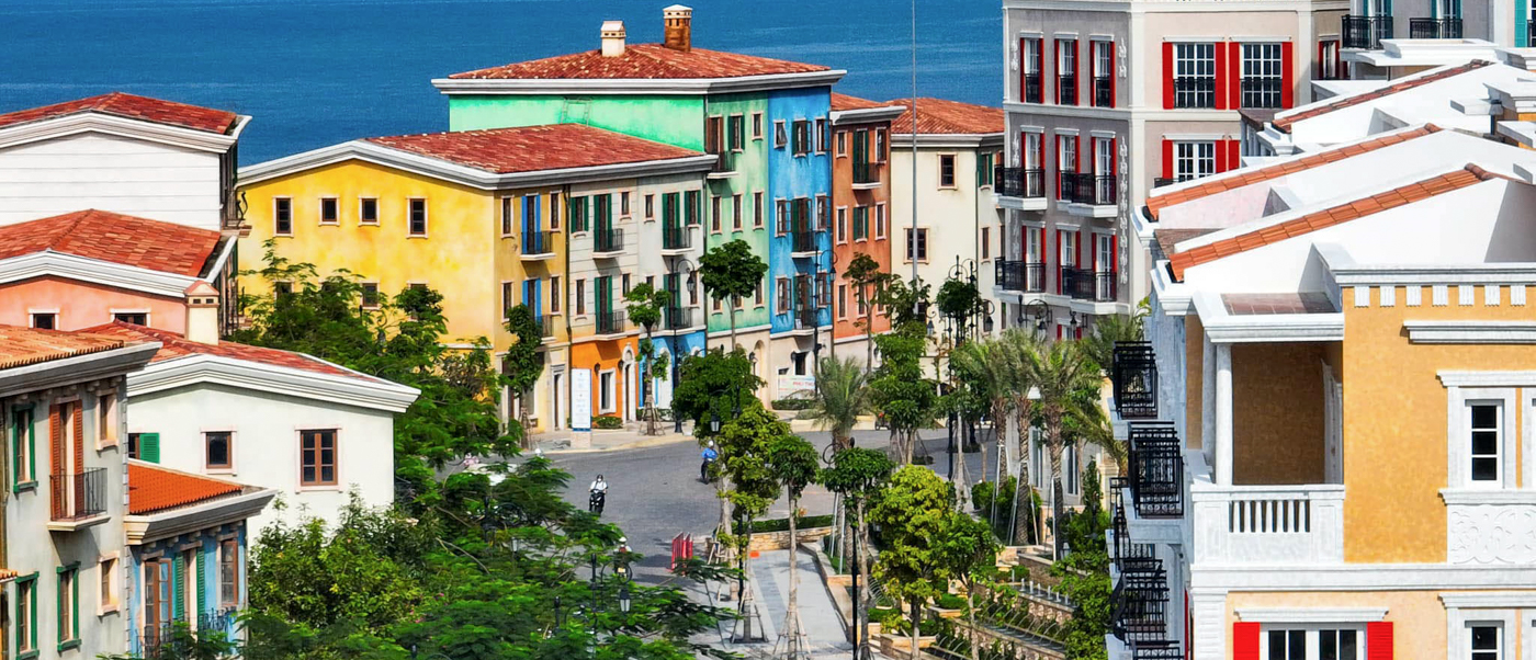 Colorful buildings with red roofs and palm trees overlook the sea in Phu Quoc's Sunset Town.