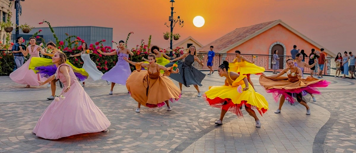 Energetic dancers in colorful, flowing dresses perform a vibrant show at sunset in Phu Quoc.